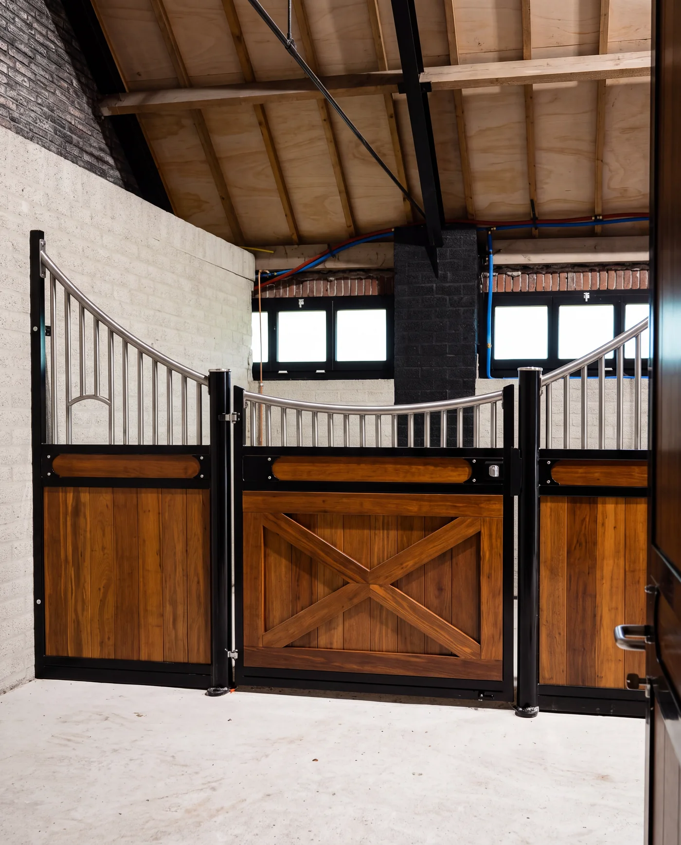 Stable front with an X-braced timber door and arched grille
