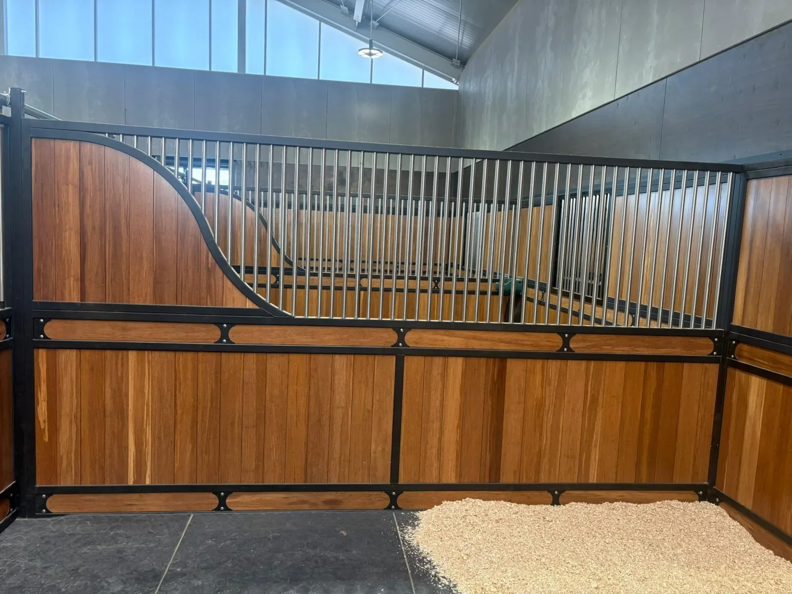 Timber and steel stable partitions with a curved grille top
